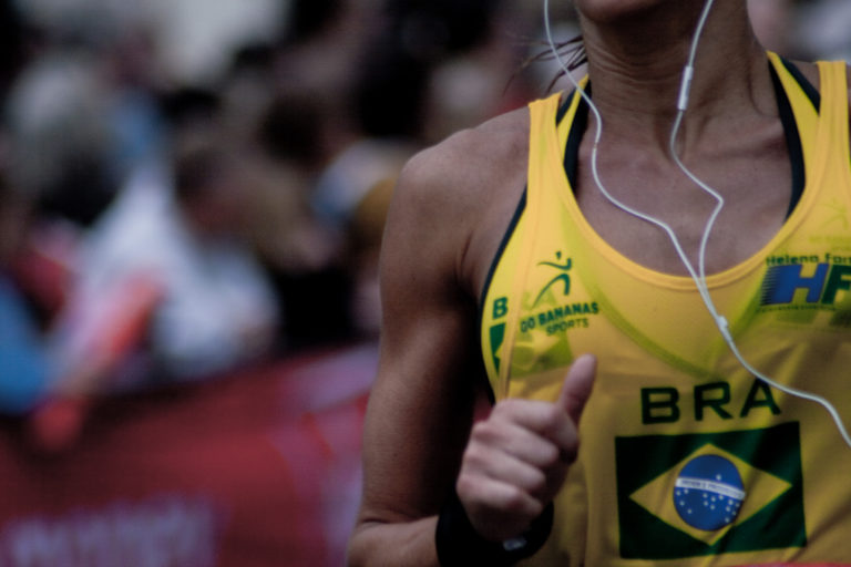 Atleta brasiliana mentre corre con cuffiette per ascolto musica in uno stadio