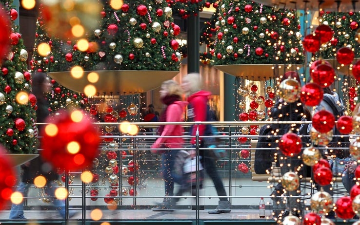 alberi di natale e addobbi natalizi con due persone sfocate che passeggiano