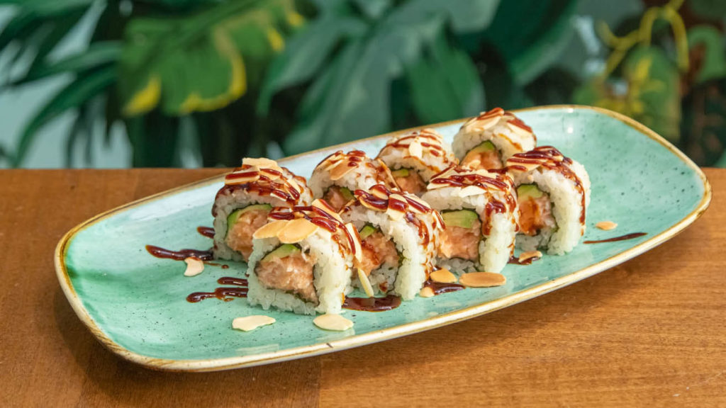 piatto con 8 pezzi di sushi denominato salmon almond bomaki posato su un tavolo