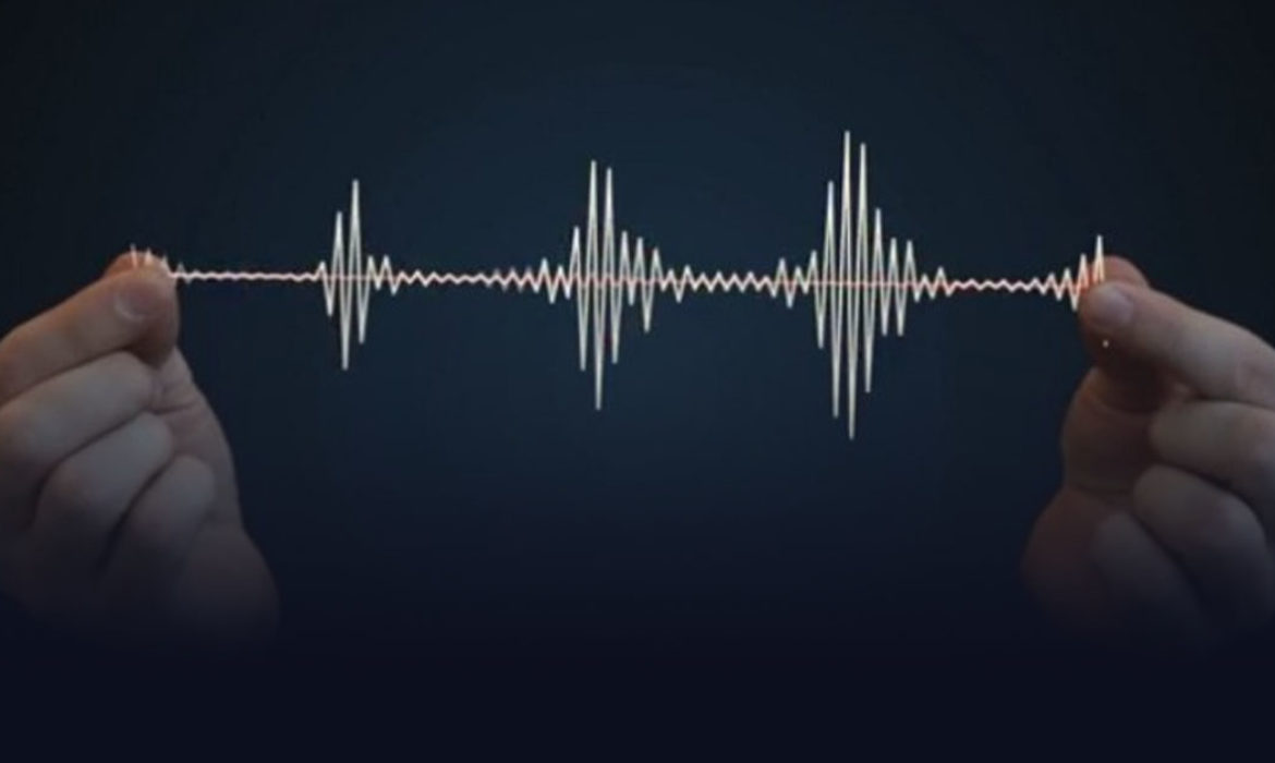 due mani che tengono tra le dita una rappresentazione di spettro del suono
