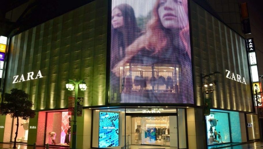 esterno negozio ad angolo di Zara con maxi ledwall e vista vetrine da entrambe i lati della strada