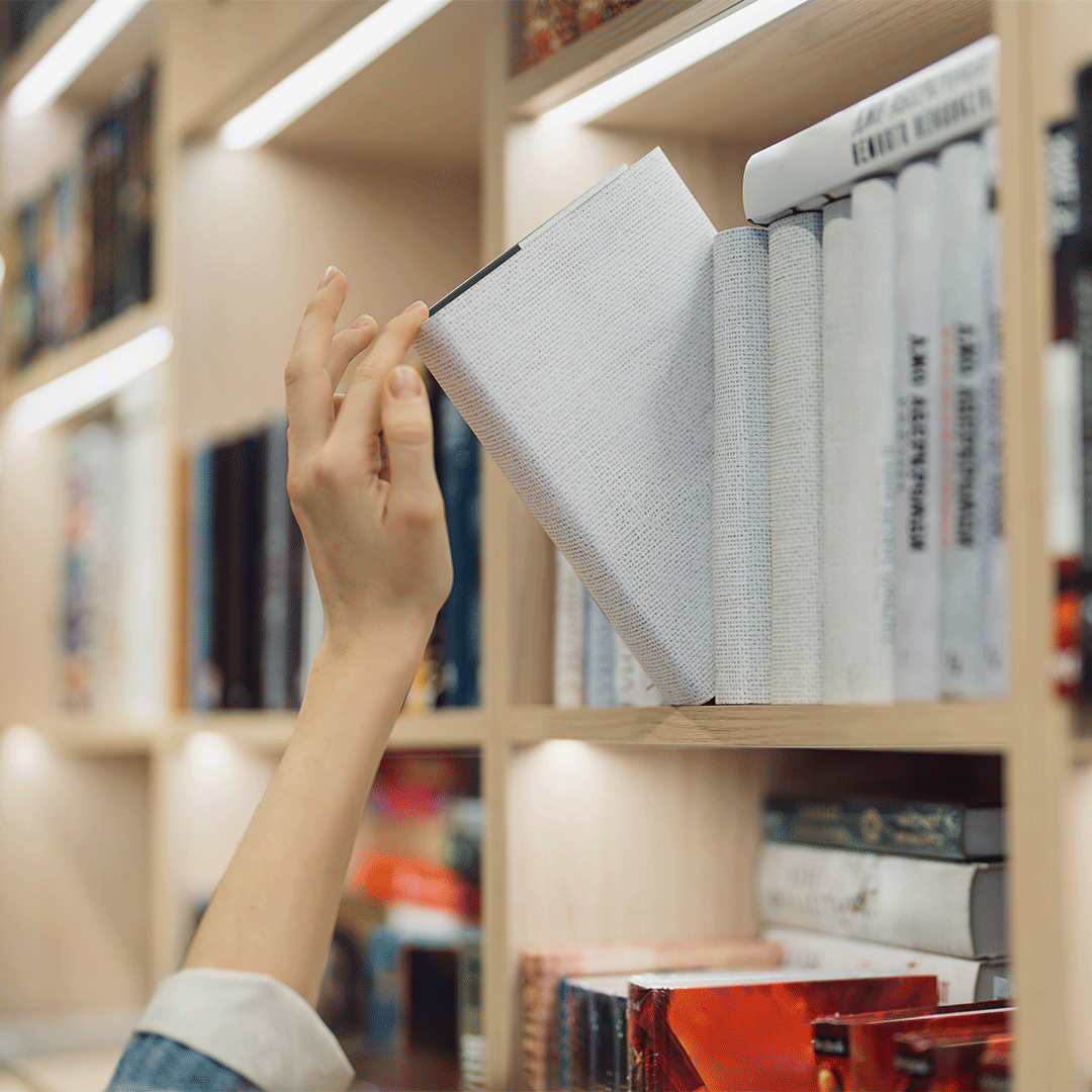 person-selecting-a-book-from-a-contemporary-library