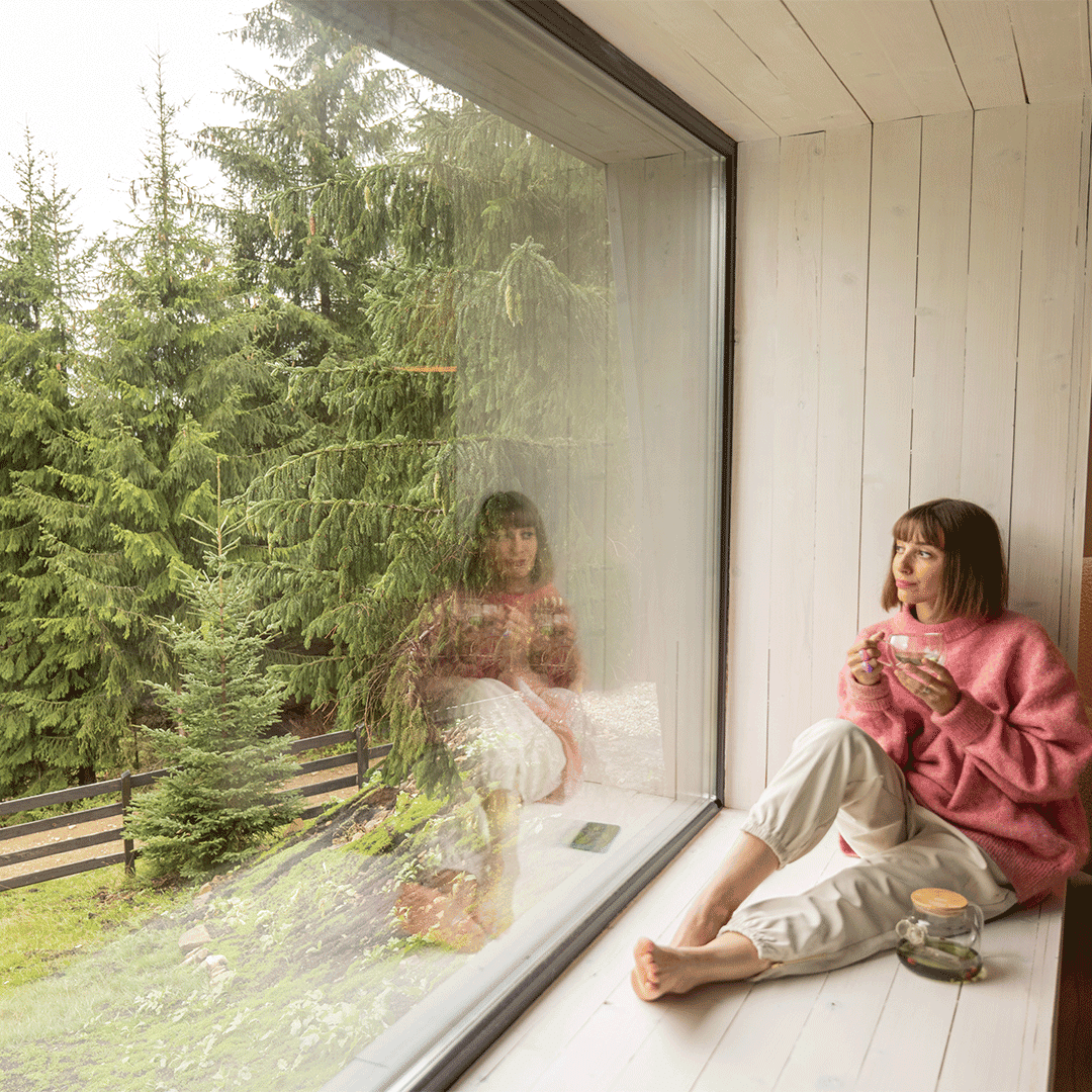 woman-rests-in-house-with-scenic-view-on-mountains